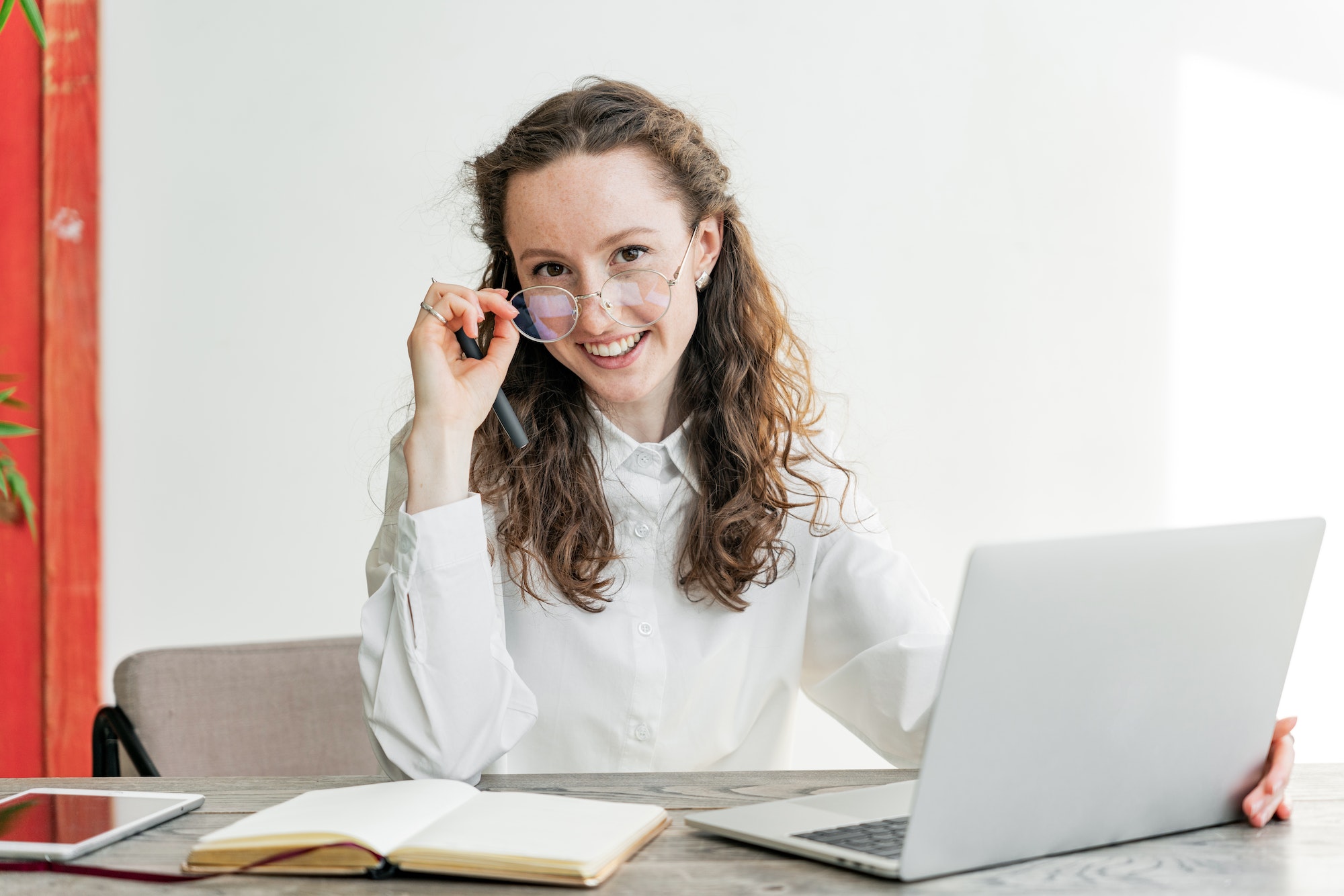 A student is a smart woman with glasses, a freelancer, a person using a computer for online work in