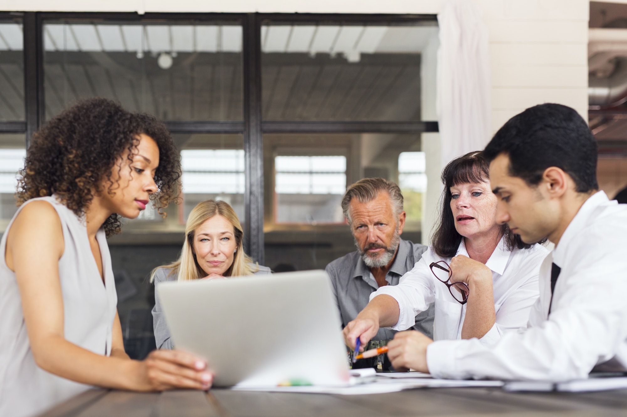 Business people using laptop at meeting in office